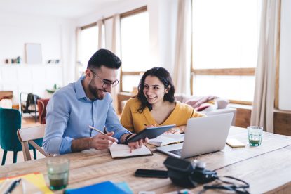 Couple looking at tablet about to sign a document