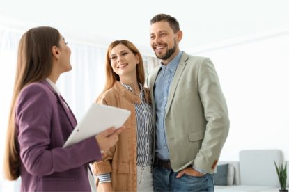 A happy couple having a conversation with a mortgage specialist.