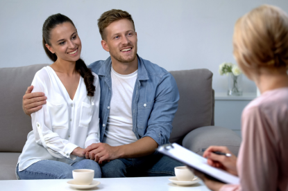 A happy couple talking with a mortgage advisor in an office.